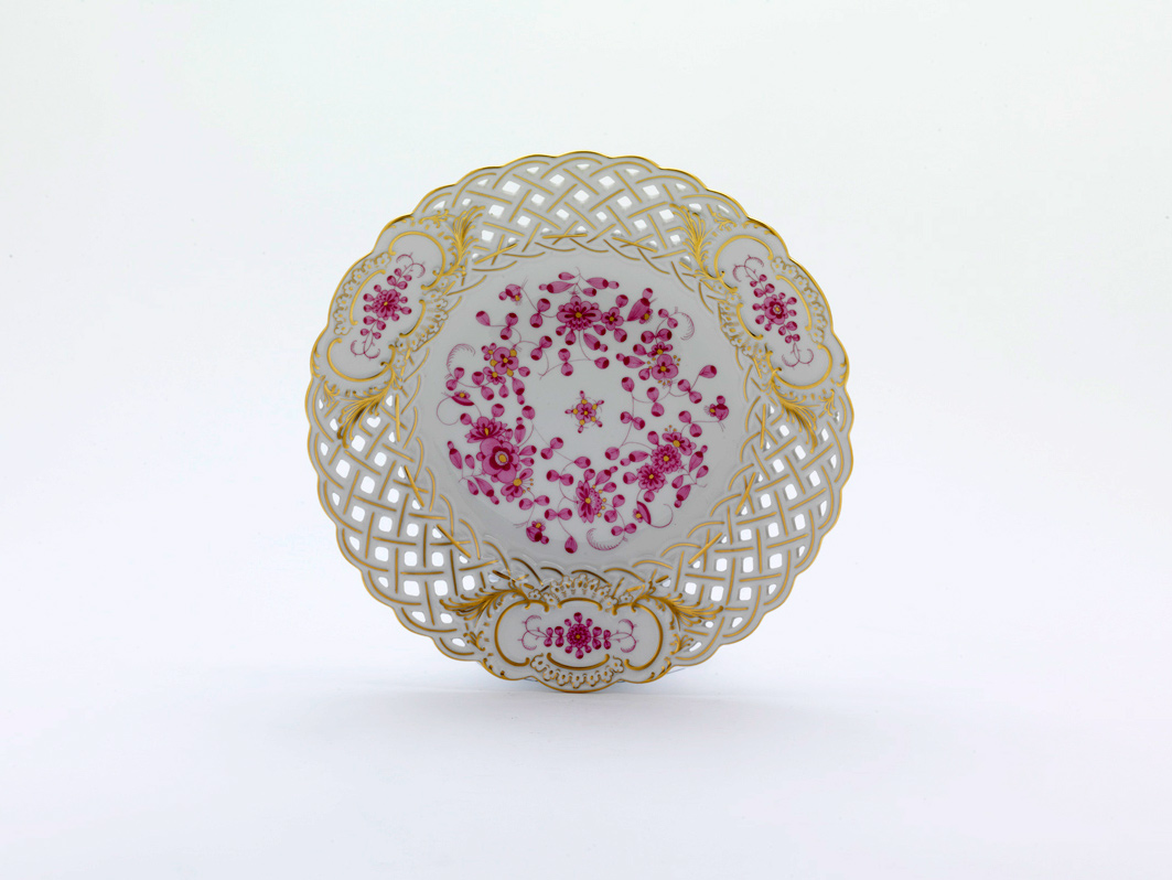 Der Teller ist 21 cm groß und hat ein durchbrochenes Muster am Rand. Er ist mit indischer Malerei in Purpur, Goldpunkten, Goldrand und Goldverzierungen dekoriert.