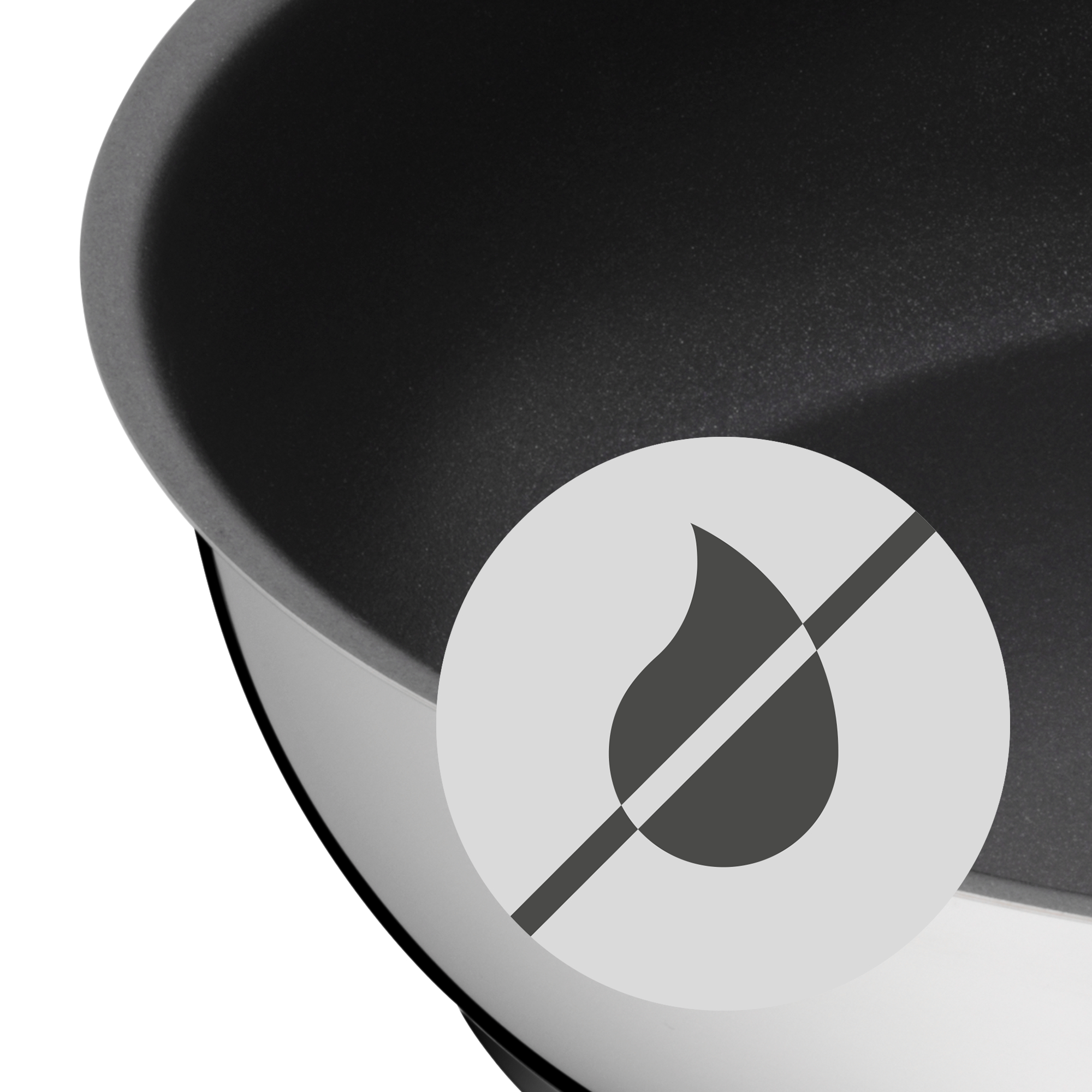 Das Bild zeigt einen Ausschnitt eines schwarzen, beschichteten Topfes oder einer Schüssel. In der Mitte befindet sich ein Symbol mit einem durchgestrichenen Tropfen, das vermutlich auf eine Antihaft- oder Trockenfunktion hinweist.