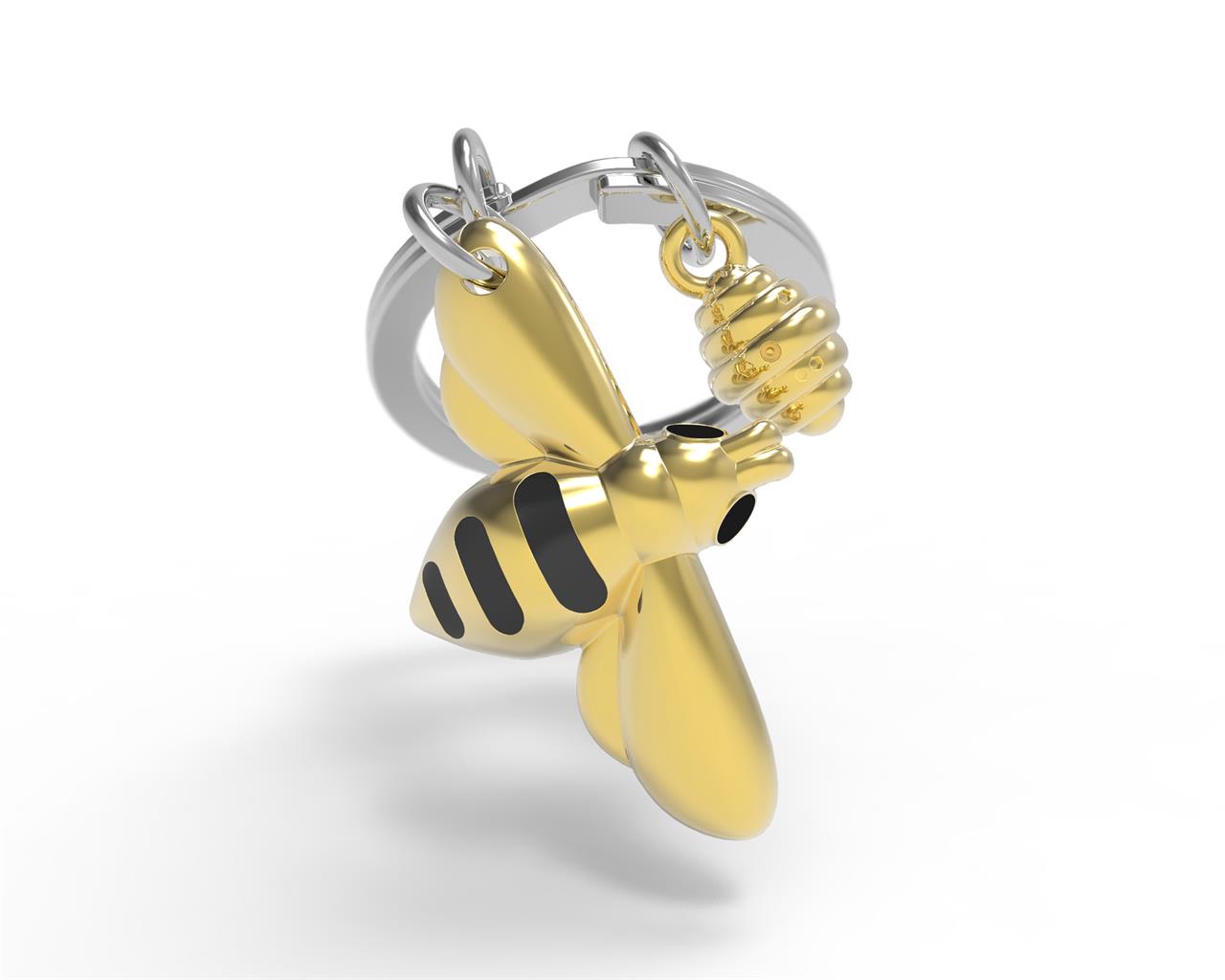 Der Schlüsselanhänger zeigt eine goldene Honigbiene mit schwarzen Streifen. Daneben hängt ein kleiner Anhänger in Form eines Bienenstocks.