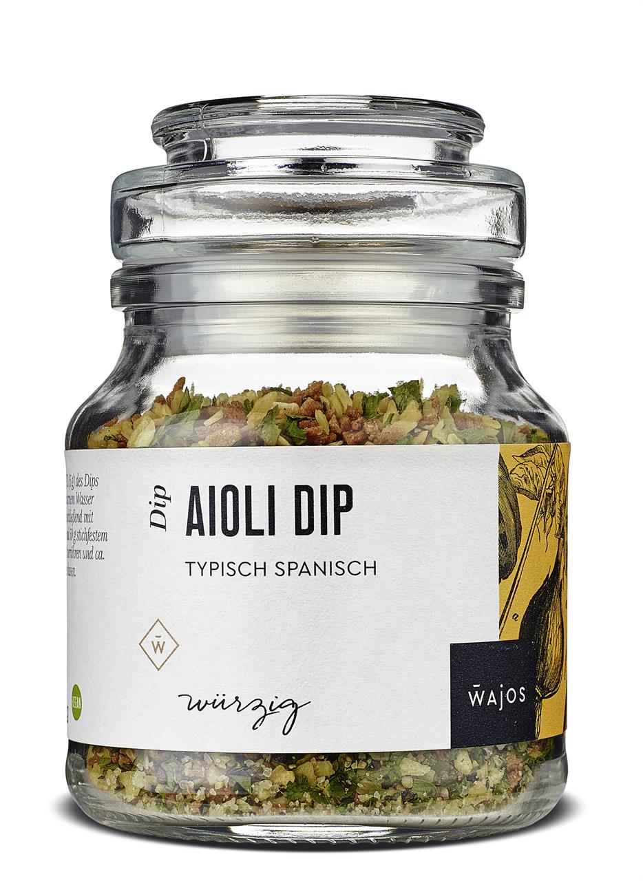 Das Bild zeigt ein Glas mit Aioli Dip Würzmischung, 115 g, von Wajos. Auf dem Etikett steht "Typisch Spanisch" und "würzig".