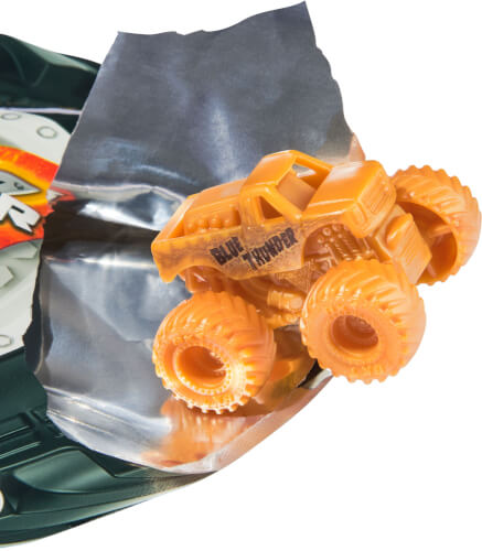 Auf dem Bild ist ein kleines, orangefarbenes Spielzeugauto in Form eines Monstertrucks zu sehen. Der Truck steht auf einer silbernen Folie, die teilweise geöffnet ist.