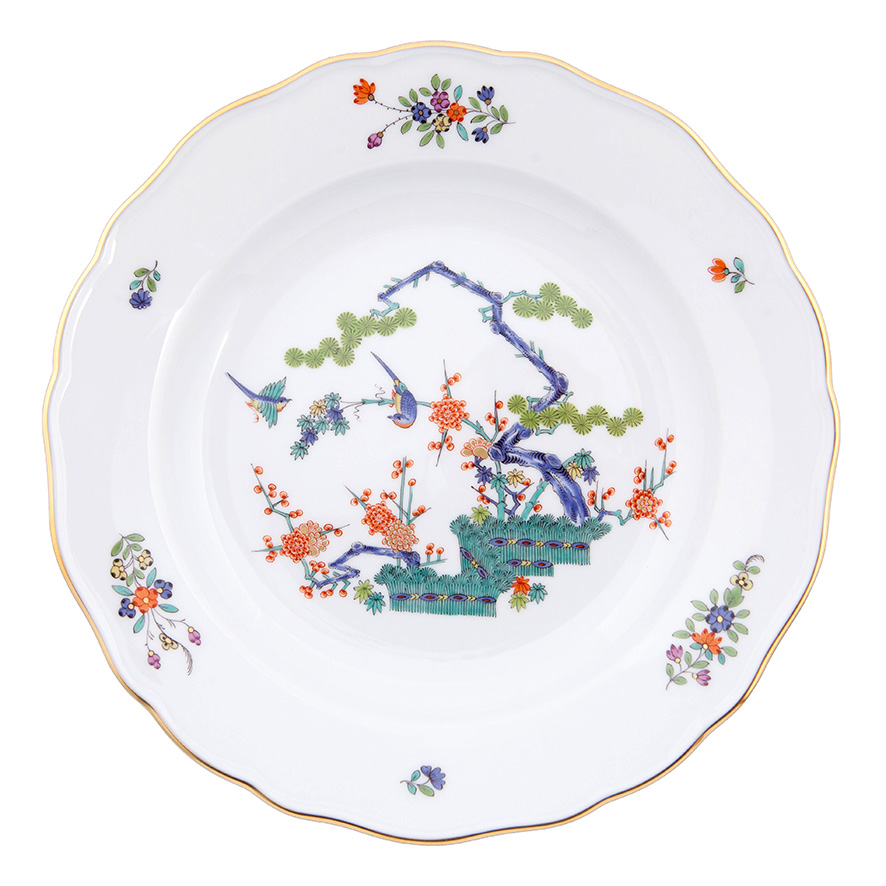 Der Teller ist 20 cm groß und zeigt ein buntes indisches Astmuster mit Vögeln und Blumen. Der Rand ist mit kupferfarbenem Gold verziert.