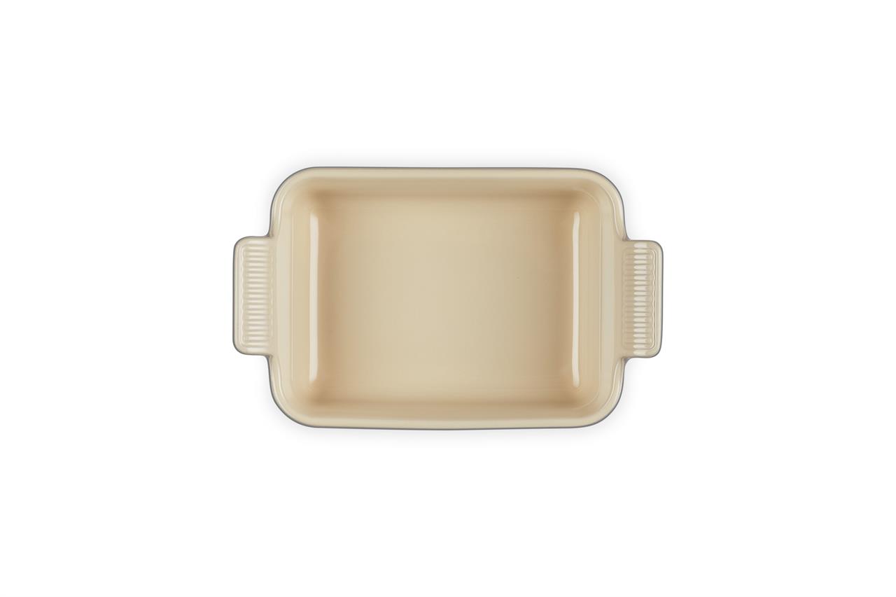 Auf dem Bild ist eine rechteckige Auflaufform in cremefarbener Optik zu sehen. Die Form hat zwei seitliche Griffe und ist das Modell "Auflaufform Tradition 19 cm Flint".