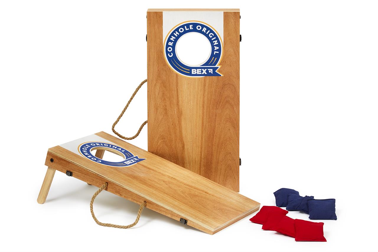 Das Bild zeigt das Spiel "Cornhole Original" mit den Maßen 60,5 x 30,7 cm, bestehend aus zwei Holzplatten mit einem Loch. Rechts im Bild liegen rote und blaue Wurfsäckchen, die zum Spiel gehören.