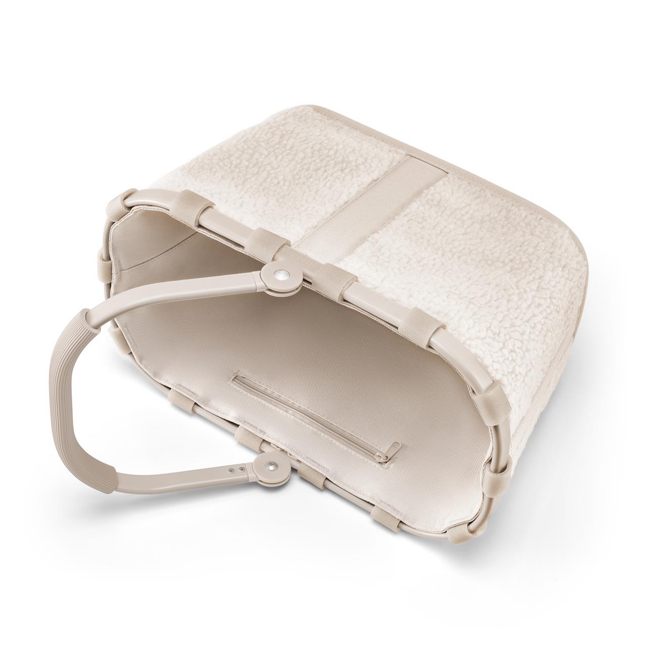 Der Carrybag XS teddy sand Einkaufskorb mini ist ein kleiner, beiger Korb mit weicher Teddy-Optik. Er hat einen stabilen Henkel und ein geräumiges Innenfach.