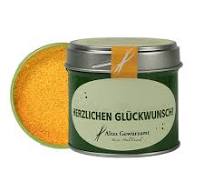 Das Bild zeigt eine grüne Geschenkdose mit der Aufschrift "Herzlichen Glückwunsch". Die Dose enthält 70g Curry Anapurna und der Deckel liegt daneben.