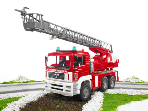 Auf dem Bild ist ein rotes Feuerwehrauto mit einer ausfahrbaren Drehleiter zu sehen. Das Fahrzeug steht auf einem Weg, umgeben von etwas Grün und weißen Steinen.