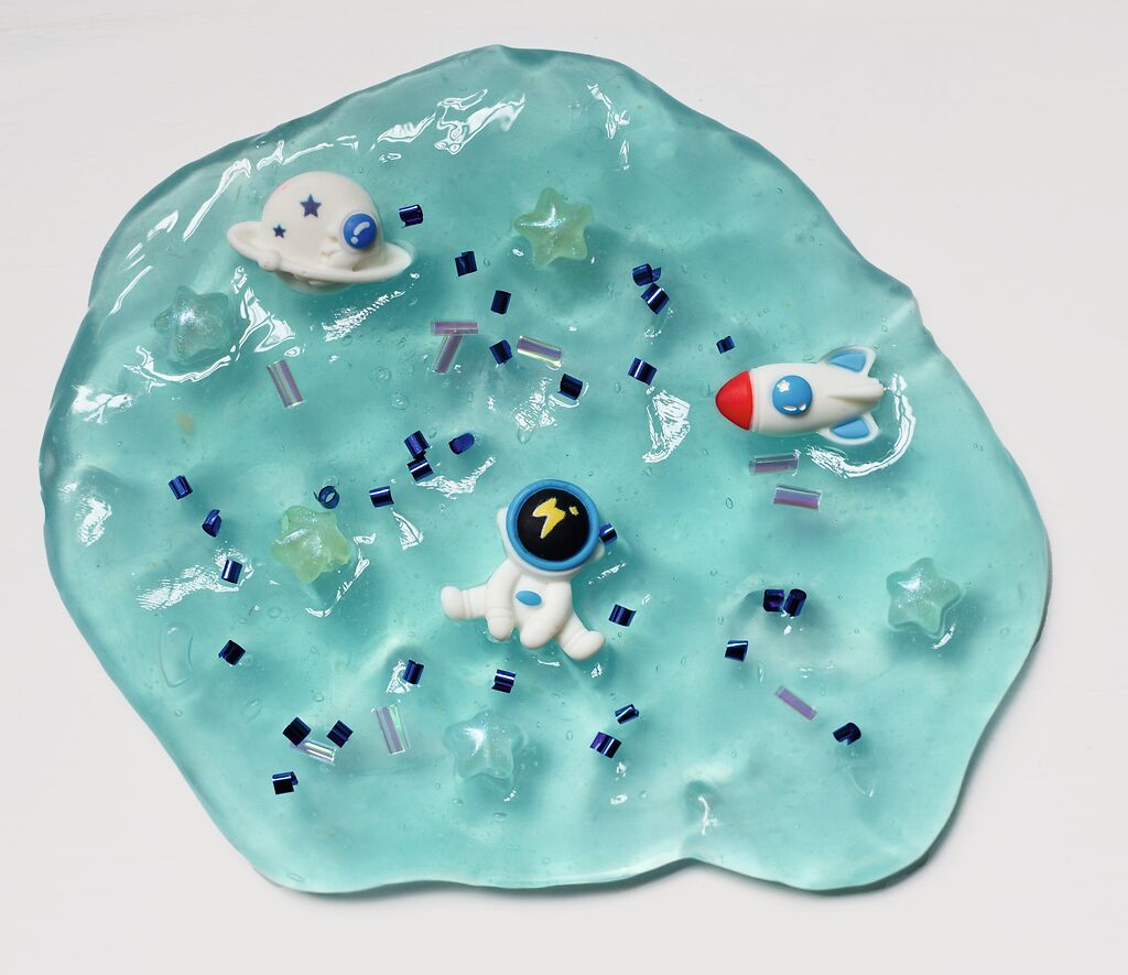 Das Bild zeigt die 'Glibber-Knete' in Blau während der Anwendung. Kinder können die Knete formen und kneten.