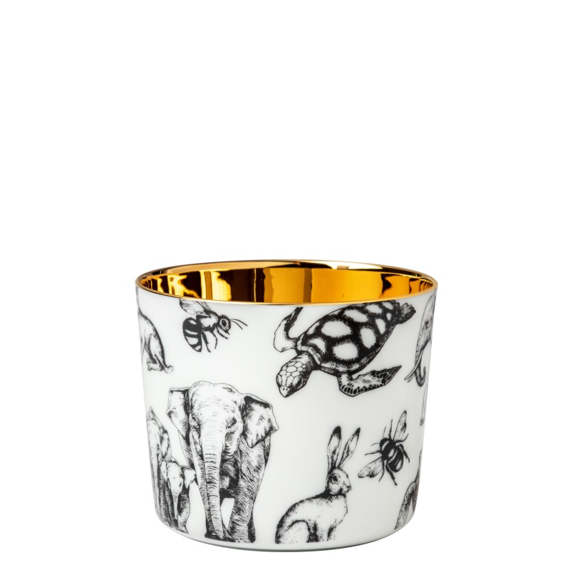 Der Champagnerbecher hat ein Fassungsvermögen von 0,25 Liter und ist von Dr. Barbara Sturm. Er zeigt schwarze Tierzeichnungen auf weißem Grund und hat eine goldene Innenseite.