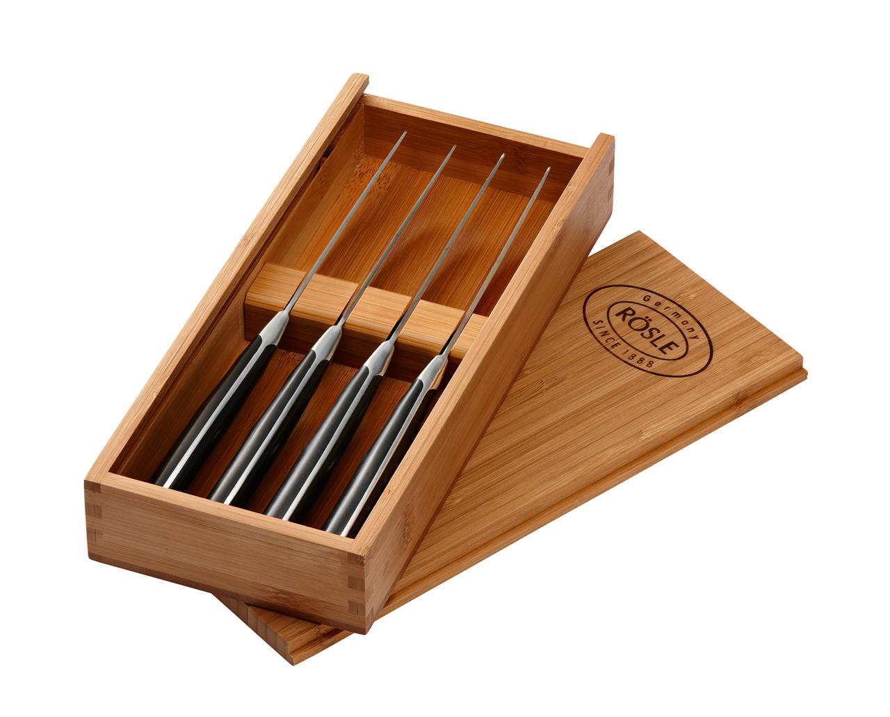 Das Bild zeigt ein Steakmesser 4er Set in einer eleganten Holzkiste. Die Messer haben schwarze Griffe und sind ordentlich in der Box platziert.