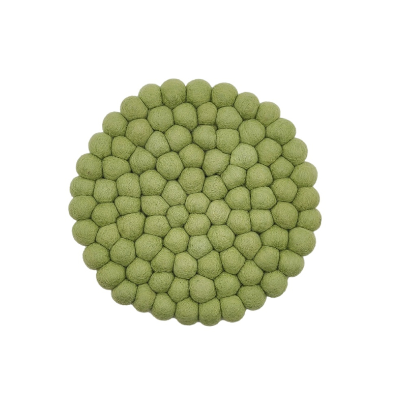 Hier sieht man einen Filz-Untersetzer aus dicken Kugeln in Pistaziengrün, Durchmesser ca. 21 cm. Er schützt Oberflächen und bringt Farbe auf den Tisch.