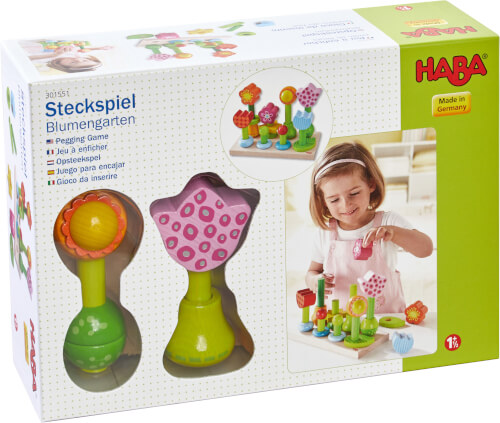 Auf dem Bild ist eine Spielverpackung von HABA mit dem Namen „Steckspiel Blumengarten“ zu sehen. Ein Kind spielt auf dem Foto rechts mit den bunten Steckblumen aus dem Set.