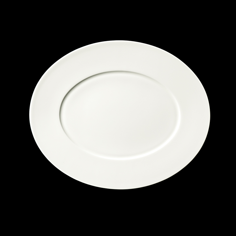 Auf dem Bild ist eine ovale, weiße Fine Bone China Platte mit einem Durchmesser von 34 cm zu sehen. Die Platte wirkt elegant und eignet sich für Fine Dining.