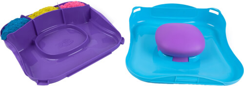 Auf dem Bild sind zwei bunte Kunststofftabletts zu sehen. Das lila Tablett hat Fächer, die mit buntem Material gefüllt sind, und das blaue Tablett hat ein rundes, erhöhtes Element in der Mitte.