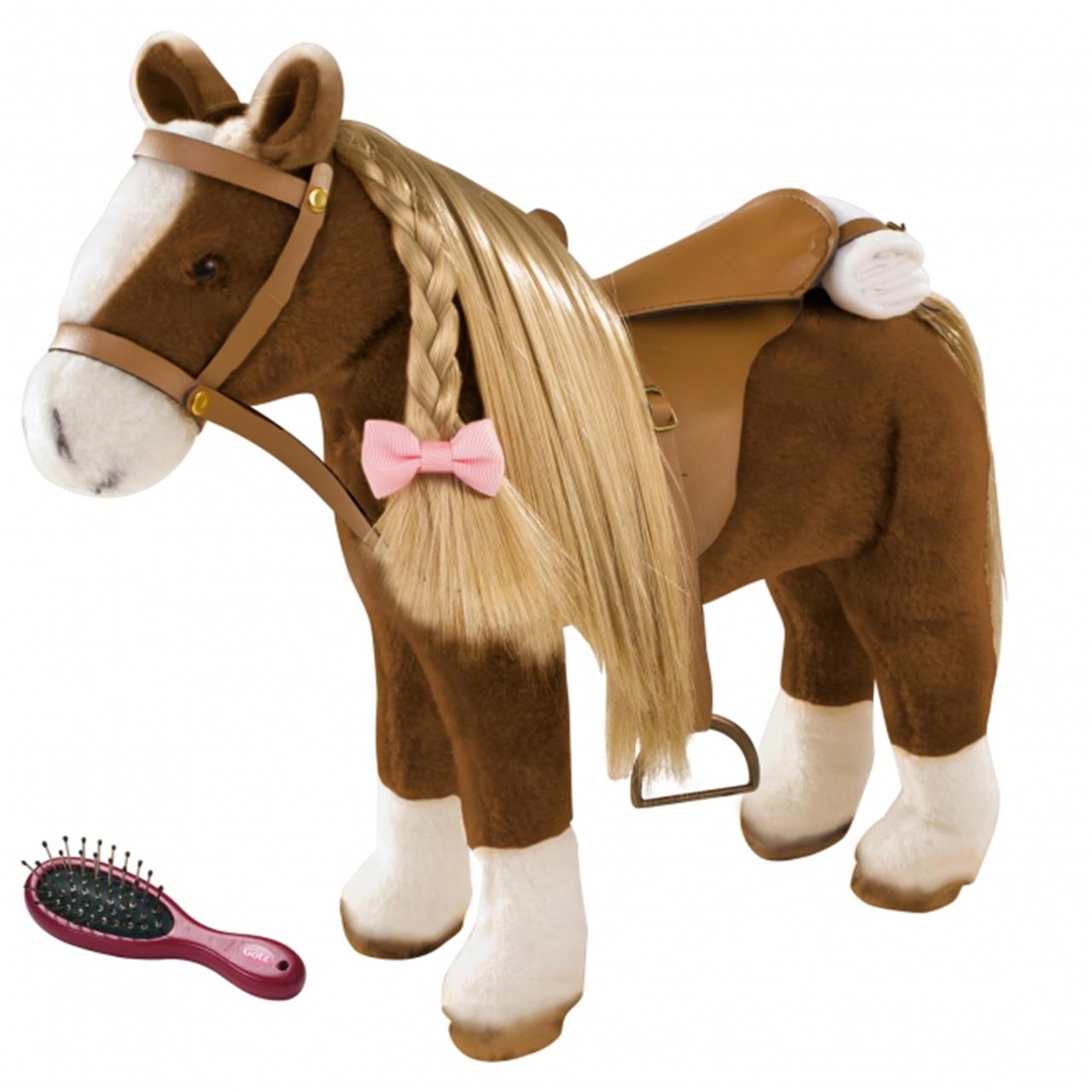 Das Bild zeigt ein großes Plüschpferd mit Sattel und Zaumzeug. Neben dem Pferd liegt eine kleine Haarbürste.