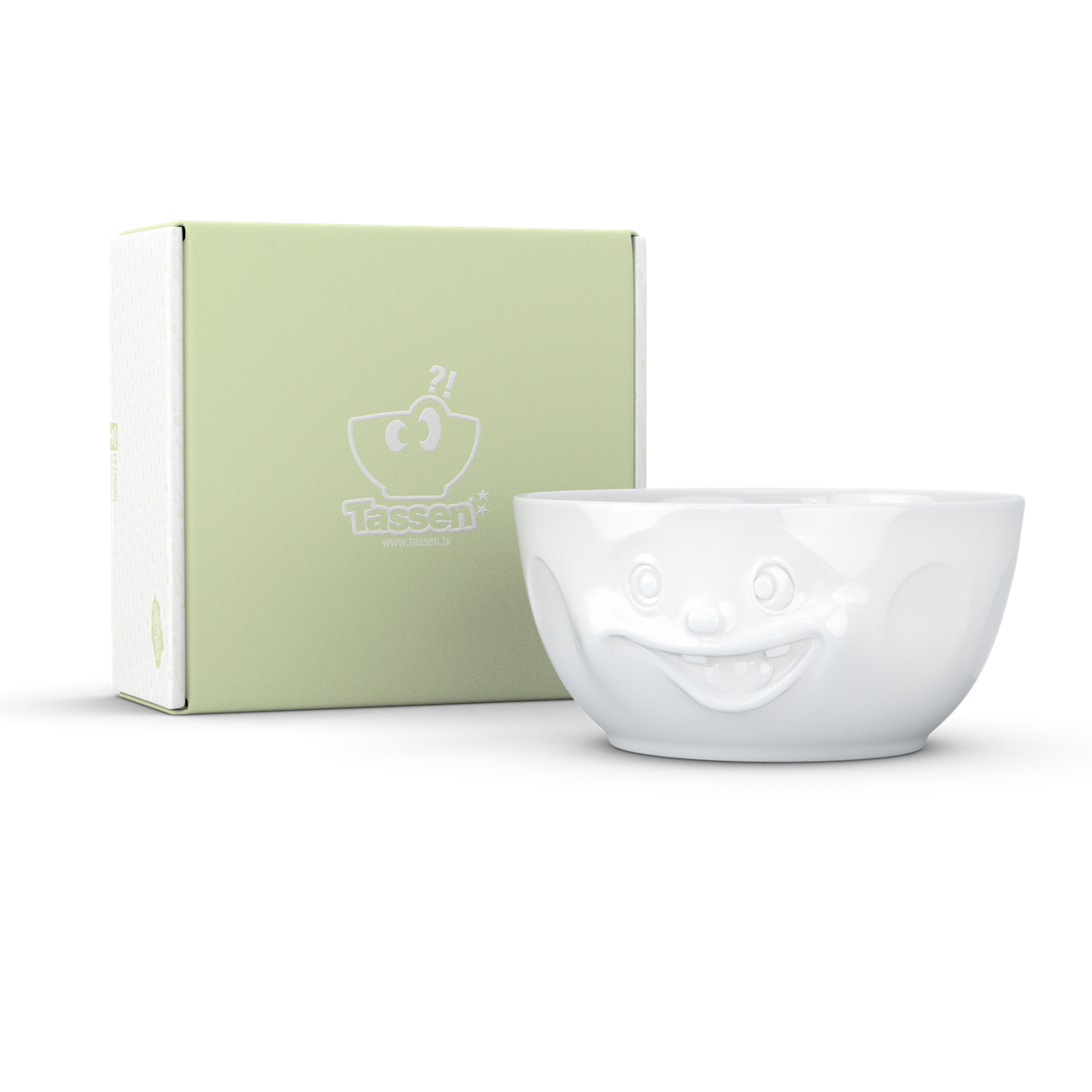 Auf dem Bild ist eine weiße Schüssel mit einem fröhlichen, lustigen Gesicht zu sehen. Daneben steht eine grüne Verpackungsbox mit dem Logo "Tassen".