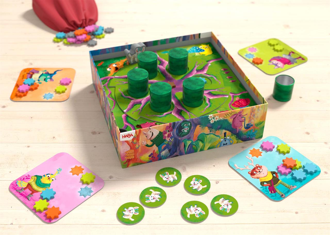 Das Bild zeigt das Brettspiel "Sternschnuppern" von HABA, das farbenfrohe Spielkarten, Spielscheiben und Spielfiguren beinhaltet. Das Spielbrett ist in einer Schachtel und zeigt eine fantasievolle, bunte Landschaft mit Tieren und Sternen.
