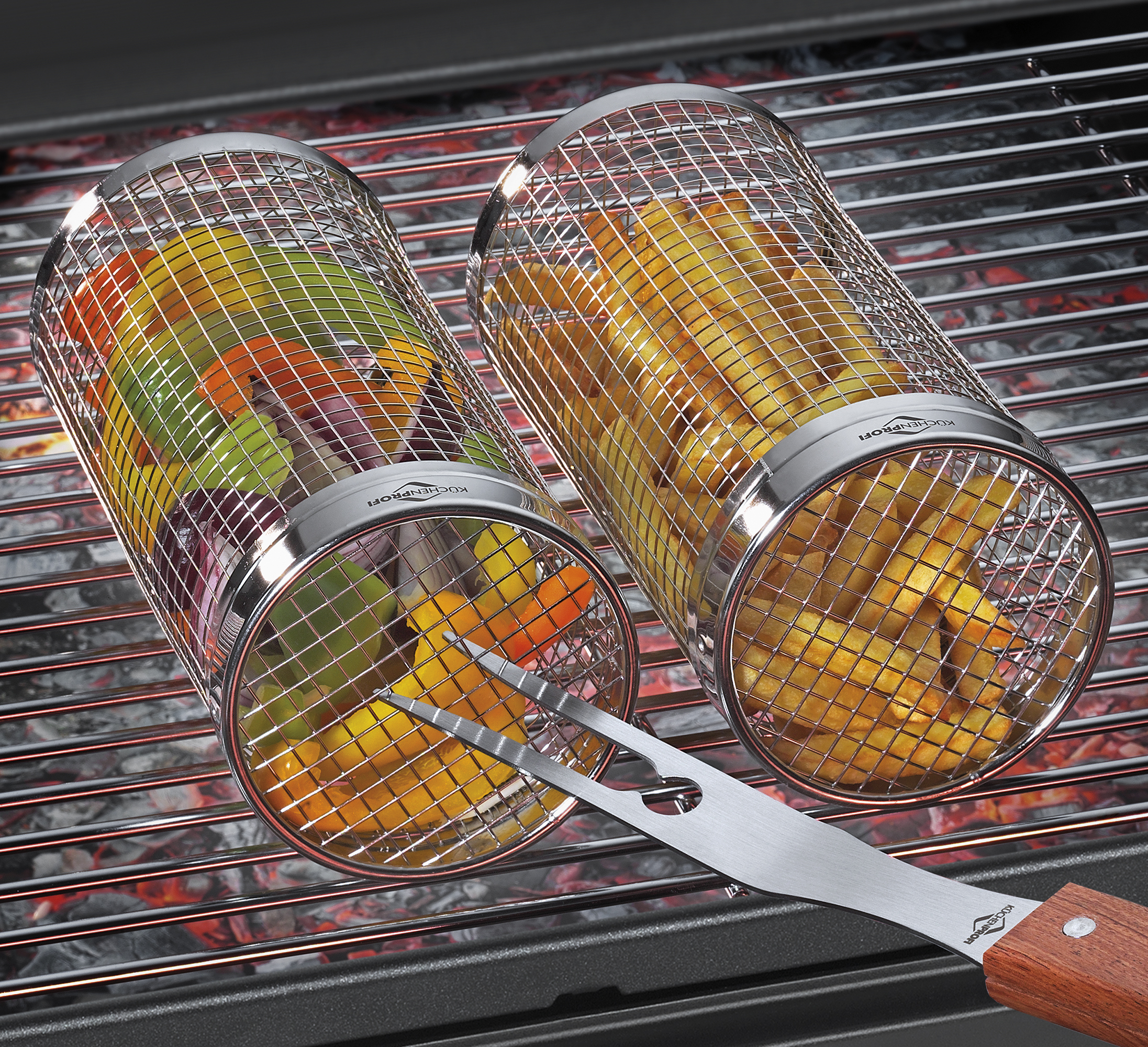 Auf dem Bild sind zwei Grillkörbe auf einem Grill zu sehen, einer gefüllt mit buntem Gemüse und der andere mit Pommes. Eine Grillzange liegt vor den Körben auf dem Grillrost.