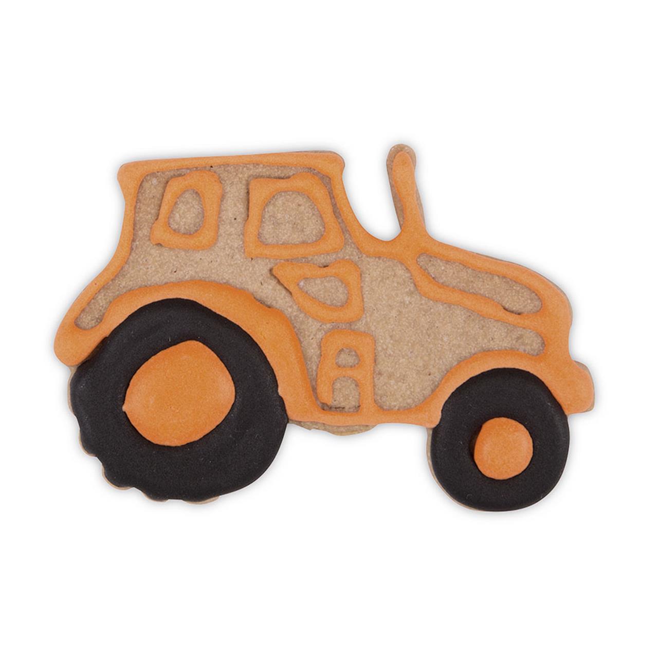 Das Bild zeigt einen Keks in Form eines Traktors, der mit orangefarbener und schwarzer Zuckerglasur verziert ist. Das Produkt heißt "Ausstecher, Traktor 7,5cm".
