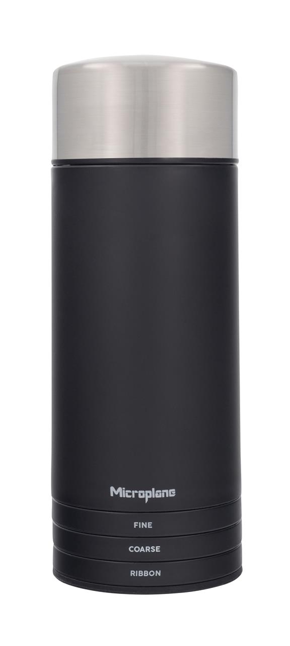 Das Bild zeigt das Produkt "Universal Mühle 3 in 1" von Microplane. Es ist eine schwarze Mühle mit silbernem Deckel und drei Einstellungsoptionen: Fein, Grob und Band.