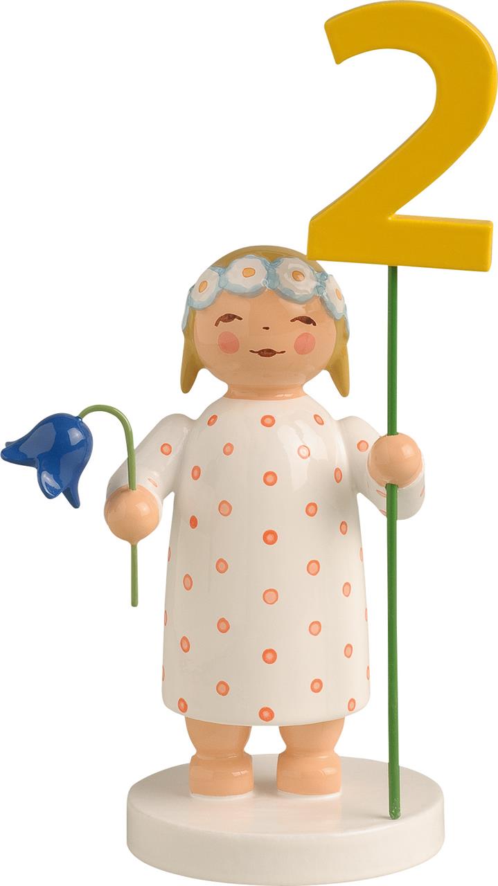Die Figur zeigt ein Mädchen im weiß-roten gepunkteten Kleid mit Blumenkranz. Es hält eine blaue Blume und eine gelbe Zahl Zwei in den Händen.