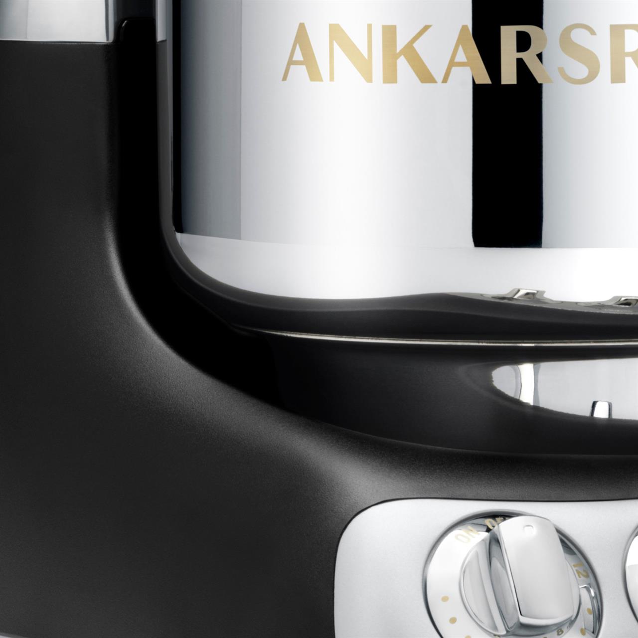 Das Bild zeigt einen Ausschnitt einer Küchenmaschine in Schwarz. Man sieht einen silbernen Drehknopf und einen Teil der Edelstahlschüssel mit dem Schriftzug "ANKARS".