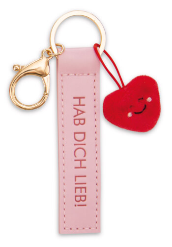 Der Schlüsselanhänger besteht aus einem rosa Anhänger mit der Aufschrift "HAB DICH LIEB!". Daran hängt ein kleines, rotes, herzförmiges Plüsch mit einem lächelnden Gesicht.