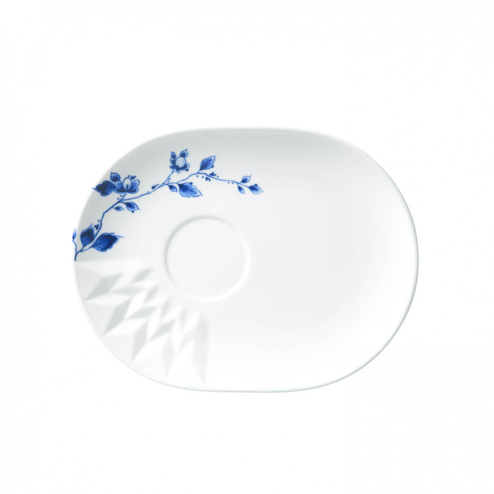 Der "Blauw Vouw Funktionsteller" ist ein ovaler, weißer Teller mit einem blauen Blumenmuster auf einer Seite. Er hat zudem ein eingeprägtes geometrisches Muster und eine Vertiefung in der Mitte.