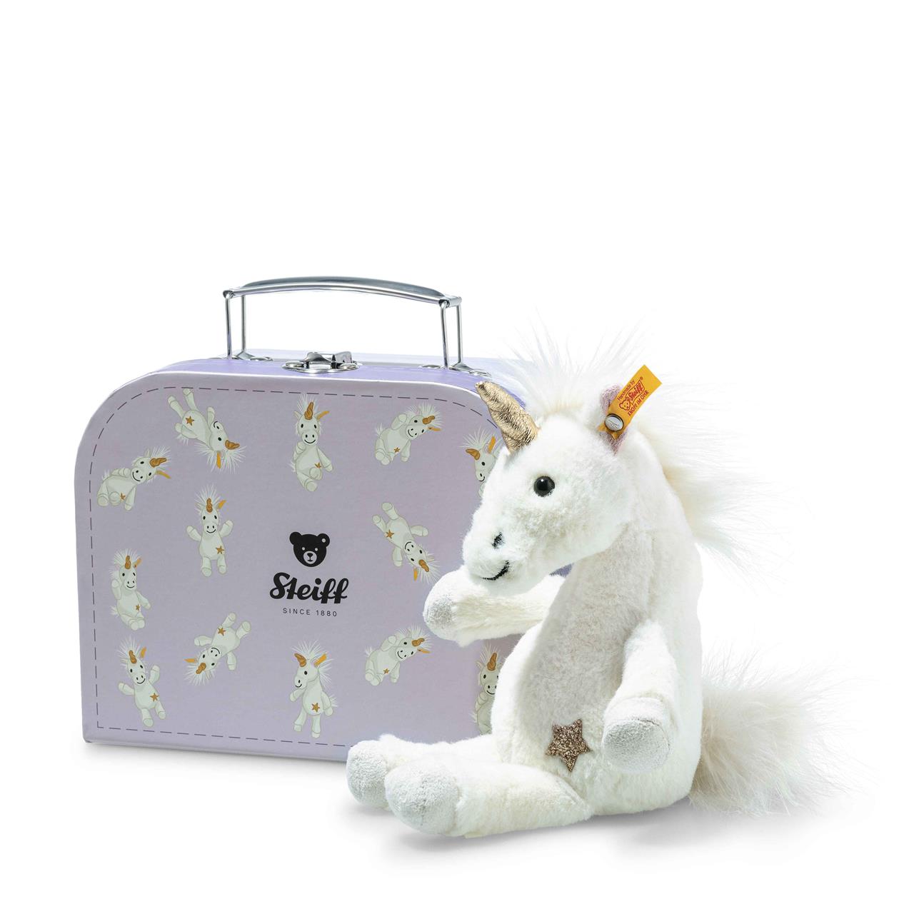 Das Bild zeigt ein weißes Einhorn-Stofftier neben einem lilafarbenen Koffer mit Einhornmotiven. Auf dem Koffer steht "Steiff" mit einem kleinen Bärenkopf-Logo.