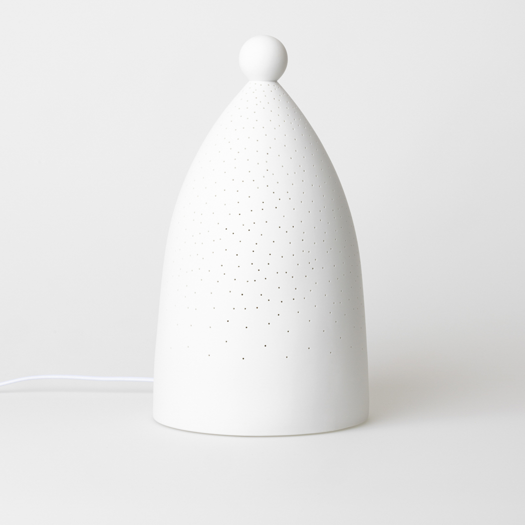 Das Bild zeigt eine weiße Lampe mit einer runden Kugel an der Spitze. Die Oberfläche der Lampe ist mit vielen kleinen Löchern versehen.