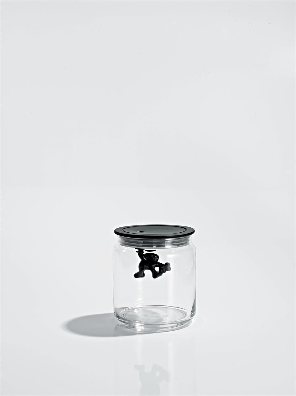 Das Bild zeigt ein Glasgefäß mit schwarzem Deckel. Im Deckel hängt eine kleine schwarze Figur, die wie ein Männchen aussieht.
