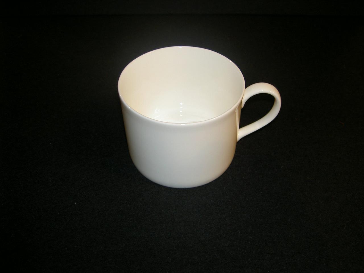 Auf dem Bild ist eine zylindrische, weiße Kaffeetasse aus Fine Bone China zu sehen. Die Tasse hat ein Fassungsvermögen von 0,25 Litern und einen Henkel.