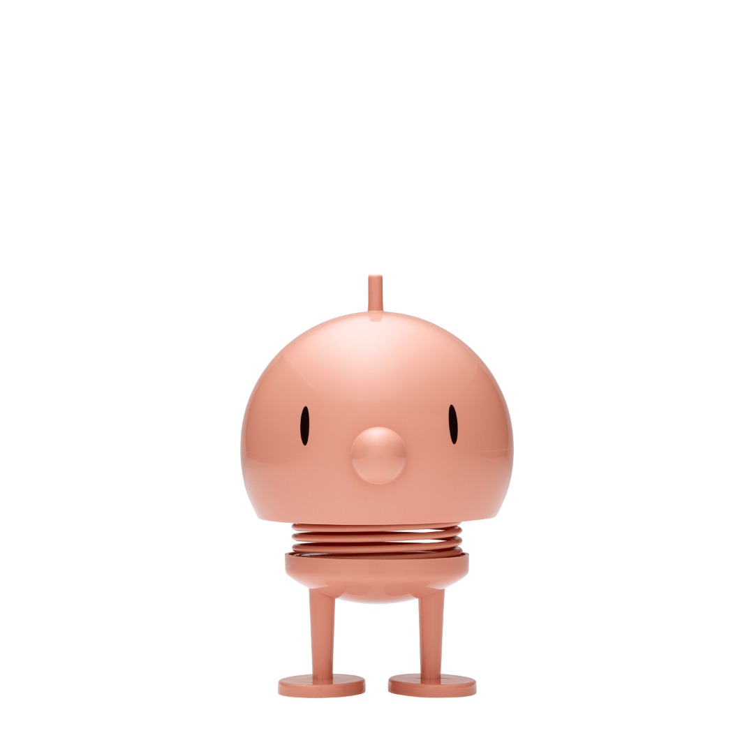 Auf dem Bild ist ein Hoptimist Bumble M in der Farbe Melon zu sehen. Die Figur hat ein rundes, lachendes Gesicht und steht auf zwei Beinen.