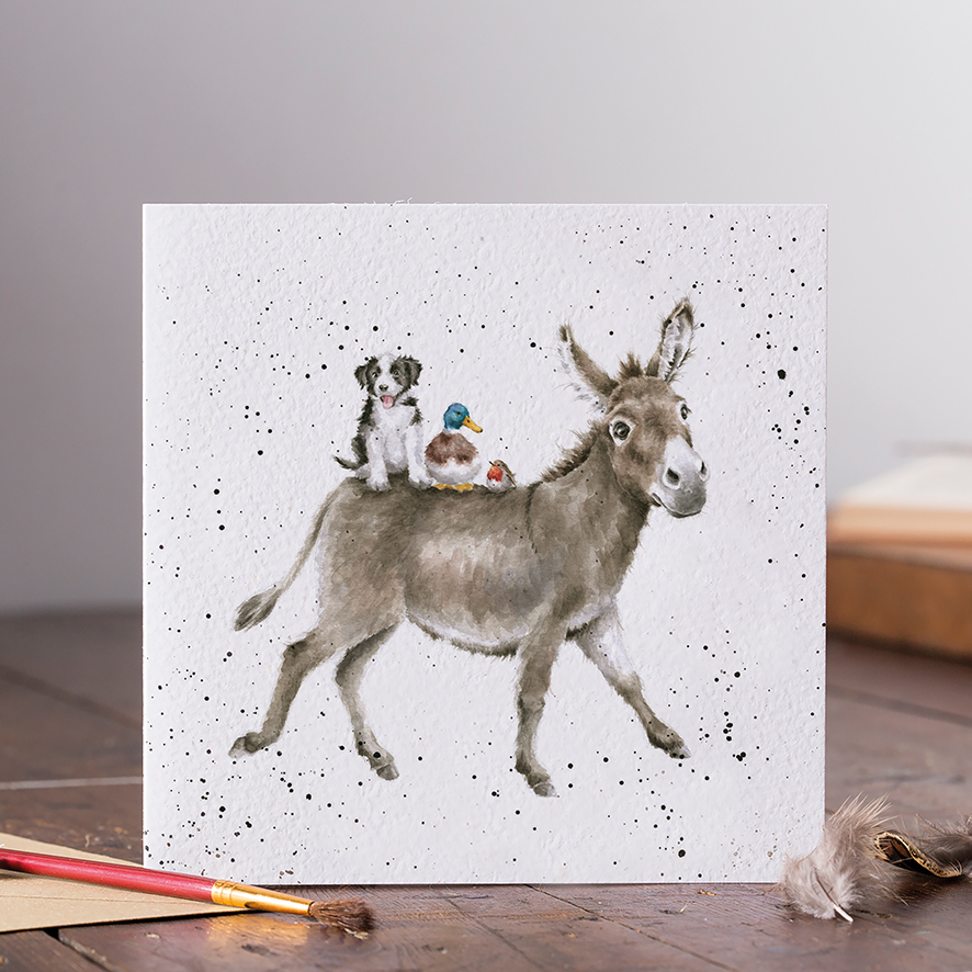 Die Karte zeigt eine niedliche Illustration eines Esels, auf dessen Rücken ein Hund, eine Ente und ein kleiner Vogel sitzen. Der Hintergrund ist weiß mit schwarzen Sprenkeln.