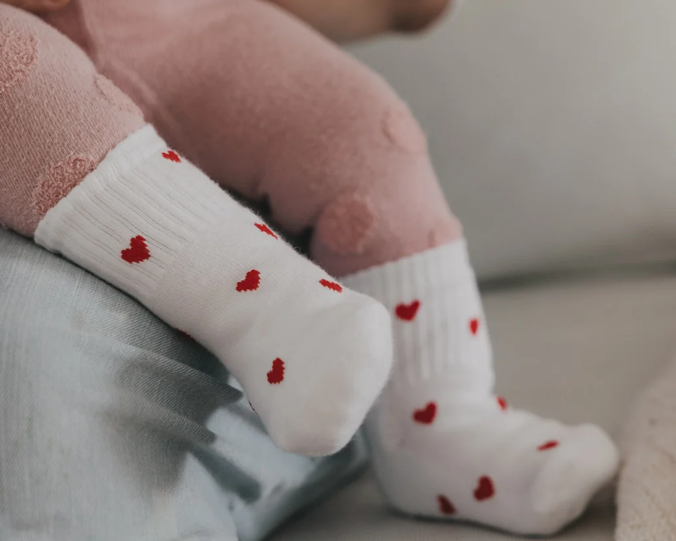 Babysocken Allover Herzen rot in den Größen 16-18 sind auf dem Bild zu sehen. Die roten Socken sind mit kleinen Herzmotiven verziert.