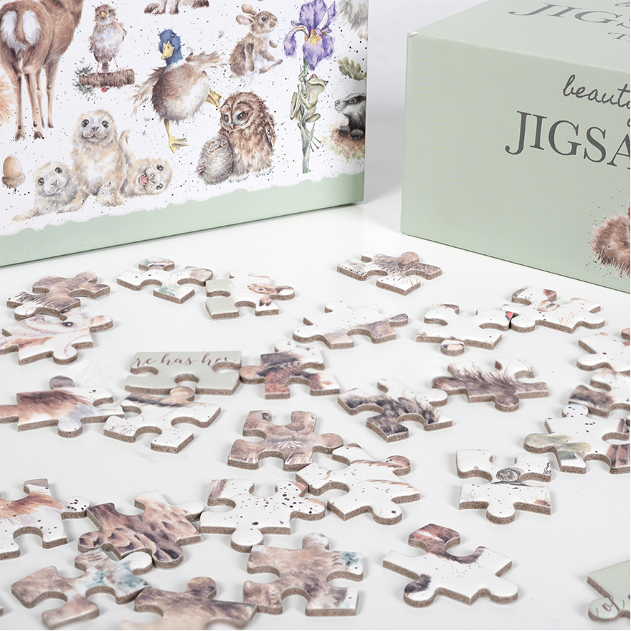 Das Bild zeigt ein Wildtierpuzzle mit 1000 Teilen, das teilweise ausgelegt ist. Auf der Verpackung sind verschiedene niedliche Waldtiere und Blumen abgebildet.