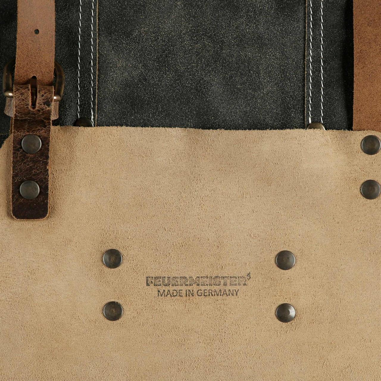 Die Abbildung zeigt eine Lederschürze aus antikem, anthrazitfarbenem Leder mit braunen Lederriemen und sichtbaren Nieten. Auf der Schürze steht "FEUERMEISTER® MADE IN GERMANY" geschrieben.