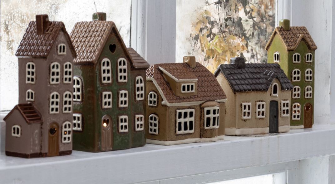 Auf dem Bild sind Keramikhäuser zu sehen. Sie stehen zusammen und bilden eine kleine Szene.