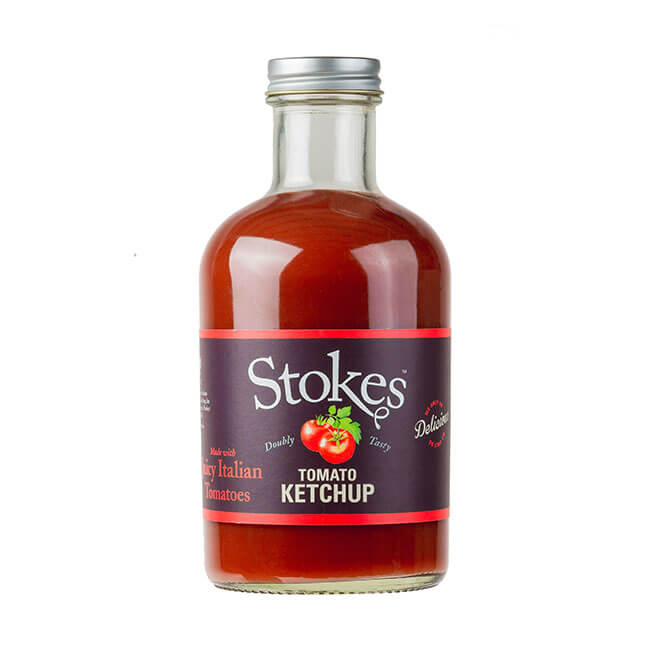 Auf dem Bild ist eine Flasche Stokes Tomato Ketchup mit 490 ml Inhalt zu sehen. Die Flasche hat ein klares Glas und ein dunkelviolettes Etikett mit einem Tomatenmotiv.