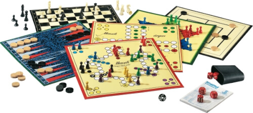 Das Bild zeigt mehrere klassische Brettspiele, die nebeneinander angeordnet sind. Man sieht Spielbretter, Spielfiguren, Würfel und Karten.