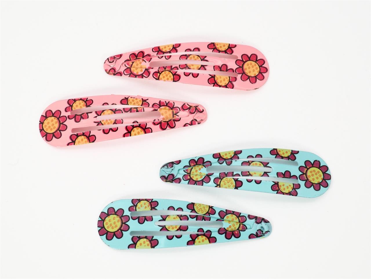 Auf dem Bild sind vier Haarspangen zu sehen, zwei in Rosa und zwei in Hellblau. Alle Spangen sind mit einem Sonnenblumenmuster verziert.