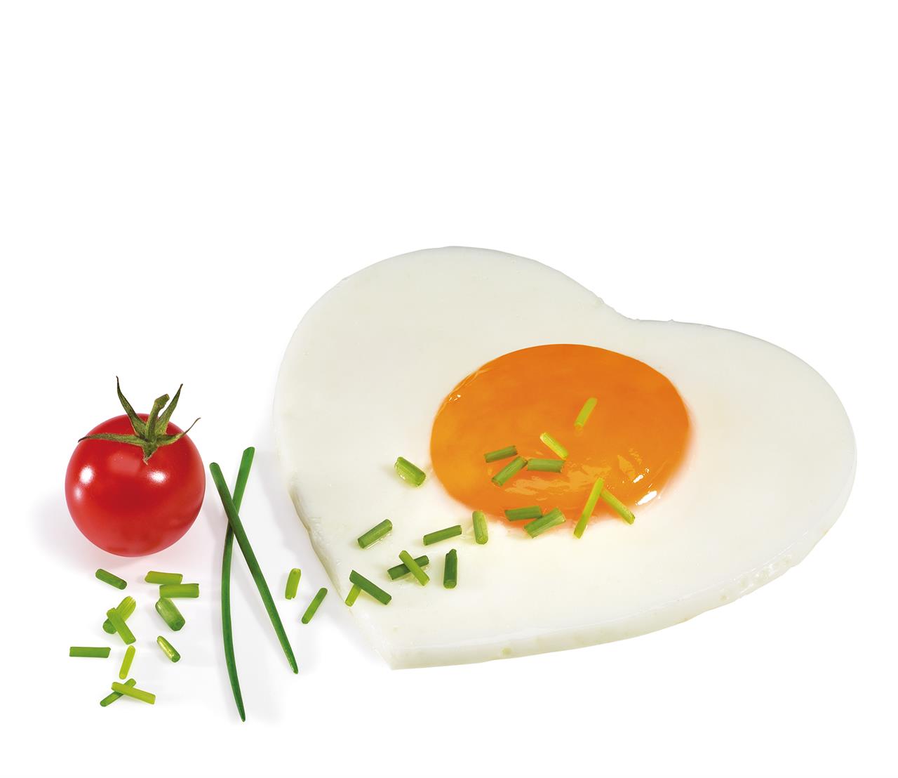 Auf dem Bild ist ein Spiegelei in Herzform zu sehen, das mit Schnittlauch bestreut ist. Daneben liegt eine kleine Tomate und etwas zusätzlicher Schnittlauch.