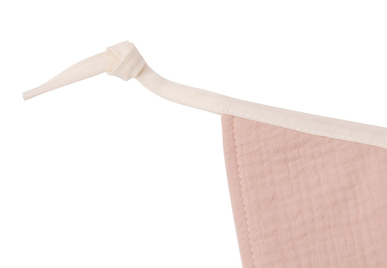Auf dem Bild ist eine Girlande aus Stoff in den Farben Rosé und Elfenbein zu sehen. Der Stoff hat eine zarte, strukturierte Oberfläche und ist an einem elfenbeinfarbenen Band befestigt.