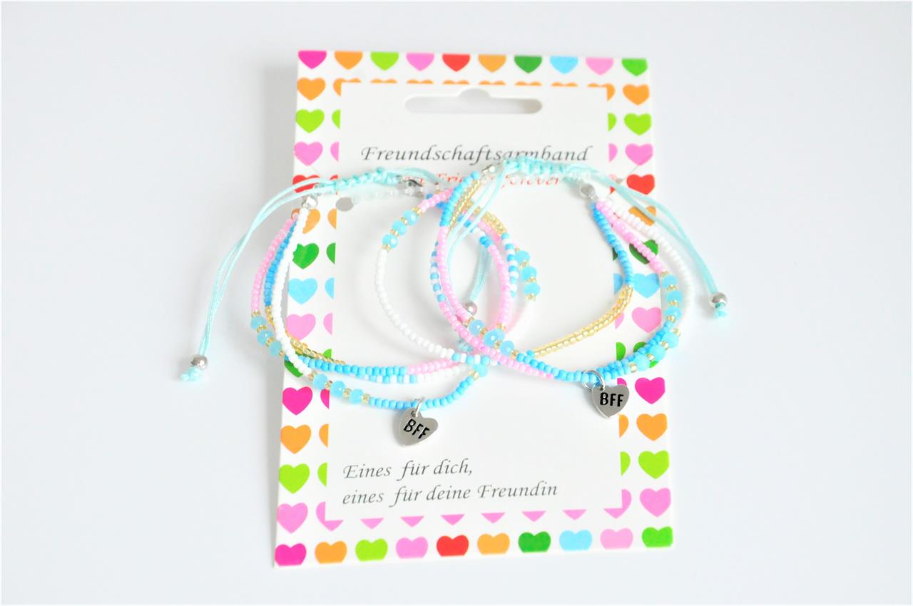 Das Bild zeigt zwei bunte Freundschaftsarmbänder mit kleinen Perlen und einem "BFF"-Anhänger. Die Armbänder sind auf einer Karte mit bunten Herzen präsentiert.