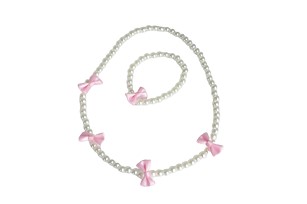 Das Bild zeigt ein Set bestehend aus einer Kette und einem Armband. Beide bestehen aus weißen Perlen und sind mit rosa Schleifen verziert.