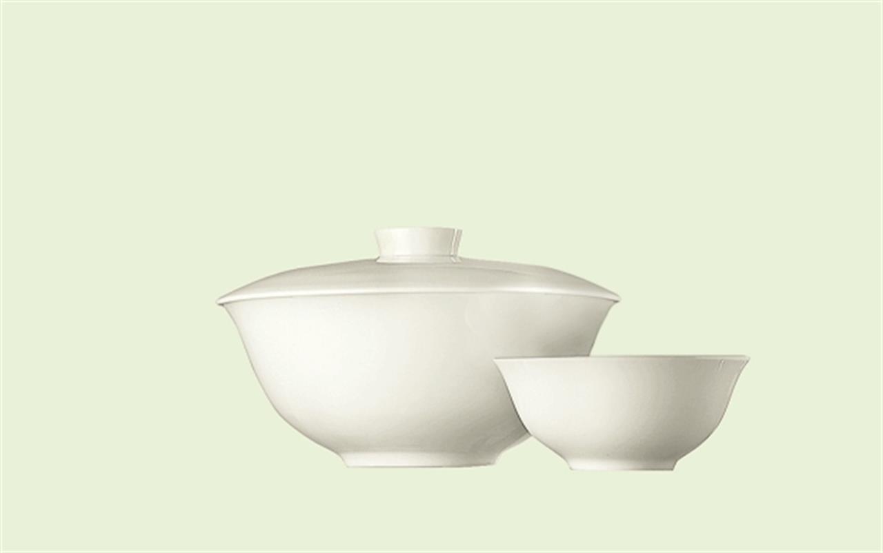 Auf dem Bild sind zwei weiße Schalen zu sehen, eine davon mit Deckel. Die Schalen sind schlicht im Design und tragen den Namen "Bowl, 14 cm, 0,40 l, Jade / Weiß".