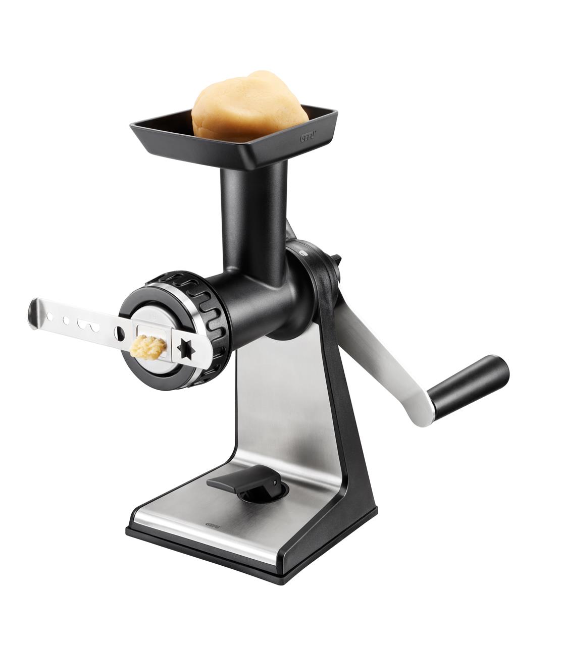 Auf dem Bild ist ein Fleischwolf Transforma zu sehen. Oben im Trichter liegt eine Portion Teig, die durch das Gerät gepresst wird.