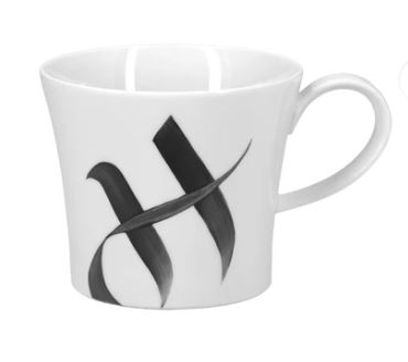 Auf dem Bild ist eine weiße Tasse mit einem stilisierten schwarzen Buchstaben "H" zu sehen. Es handelt sich um das Produkt "Becher Berlin H Alphabet Edition".