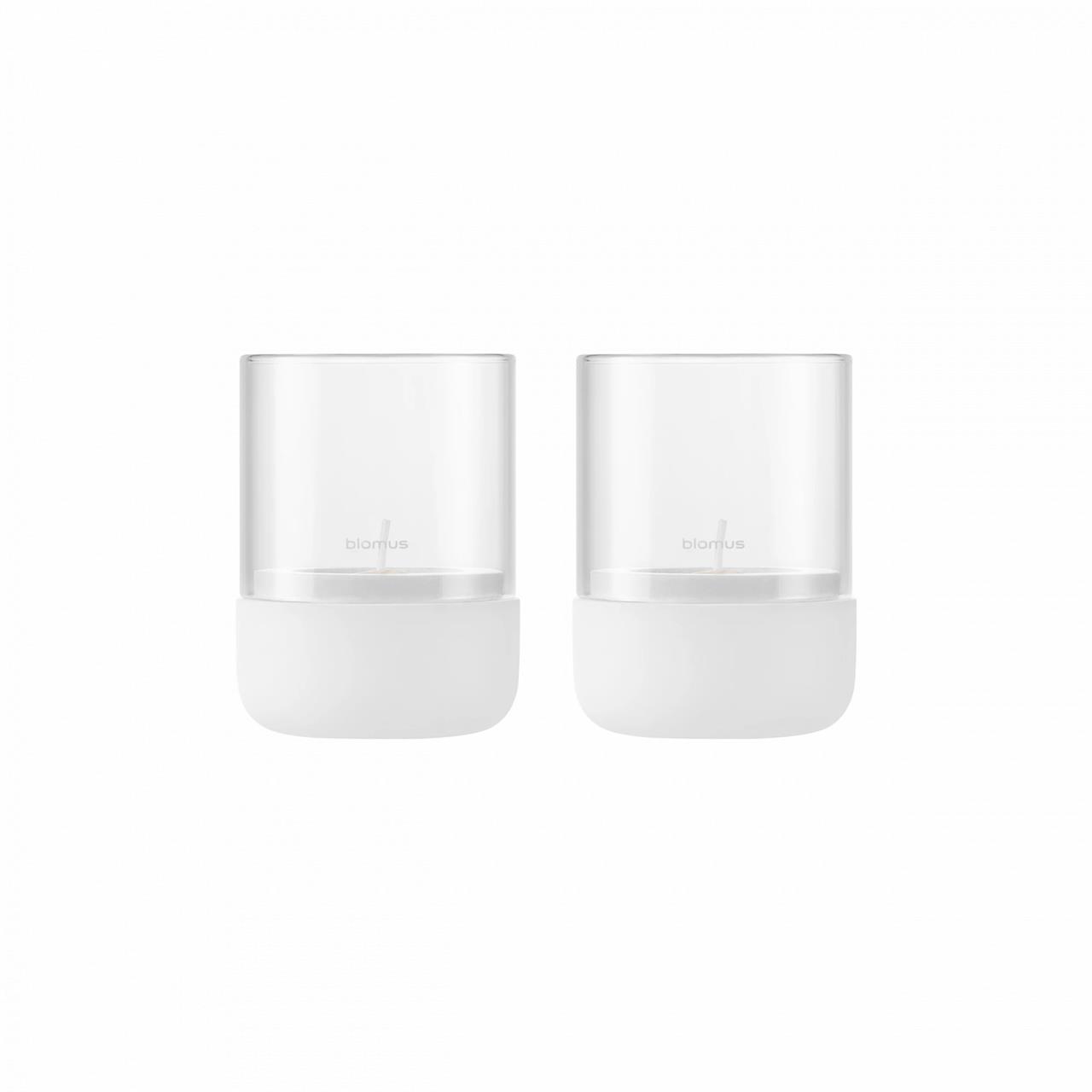 Das Bild zeigt zwei Windlichter aus der Serie CALMA in der Farbe Lily White XS. Sie haben einen schlichten, modernen Look mit einem weißen Boden und klarem Glas.