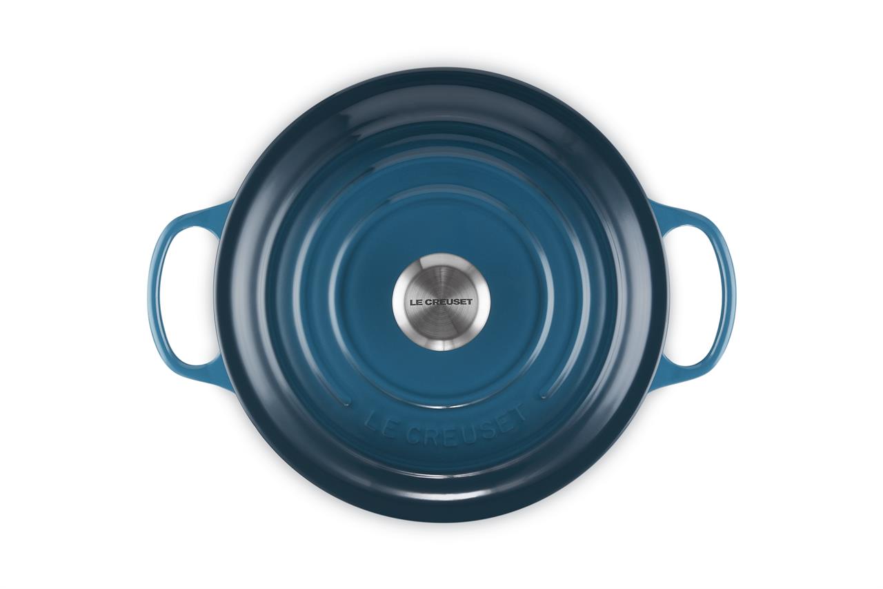 Das Bild zeigt einen runden Bräter der Marke Le Creuset in der Farbe Deep Teal mit einem Durchmesser von 26 cm. Der Bräter hat zwei Griffe und einen silbernen Knauf auf dem Deckel.